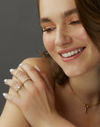 A dainty 14k yellow gold ring, with a horizontal bar on top, set with nine tiny white diamonds.