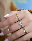 A dainty 14k yellow gold ring, with a vertical bar on top, set with nine tiny white diamonds.