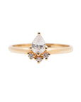 A 14k yellow gold engagement ring, set with a center pear cut white diamond and and halo of three small white diamonds.
