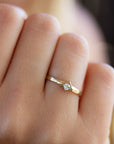 A delicate 14k yellow gold engagement ring set with a center 0.25 carat princess cut white diamond.