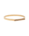 A delicate 14k yellow gold ring with a flat top set nine brilliant cut white diamonds, 0.01 carat each.