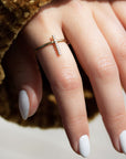 A dainty 14k yellow gold ring, with a vertical bar on top, set with nine tiny white diamonds.