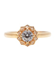 A delicate 14k yellow gold engagement ring, set with a center brilliant cut white diamond and smaller diamonds around it, in the shape of a geometric flower. 