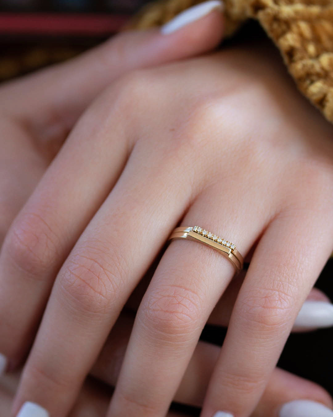 A delicate 14k yellow gold ring with a flat top set nine brilliant cut white diamonds, 0.01 carat each. 