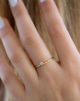 A dainty 14k yellow gold ring, set with one tiny, brilliant cut white diamond.